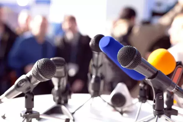 A row of microphones at a press conference