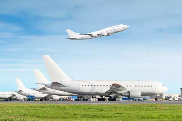 A row of airplanes, with one taking off