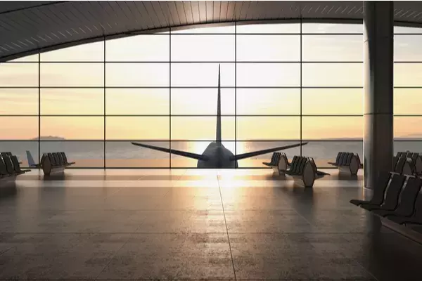 Empty airport terminal with the view of an airplane tail out the window