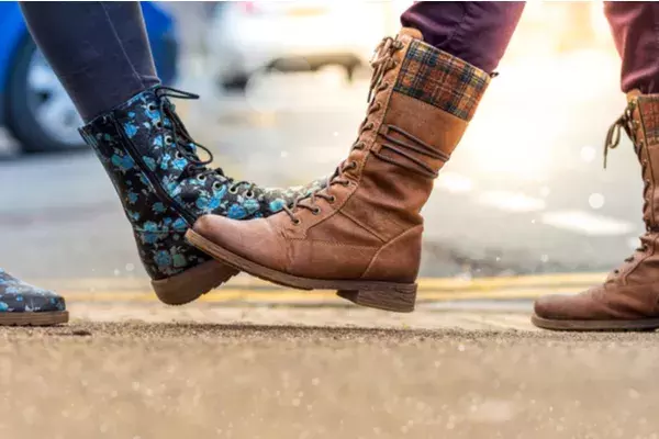 Two people tapping feet as an alternative to shaking hands