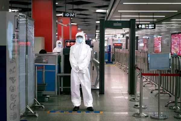 airport personnel wearing a hazmat suit and mask