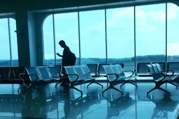 Man looking at phone in an empty airport