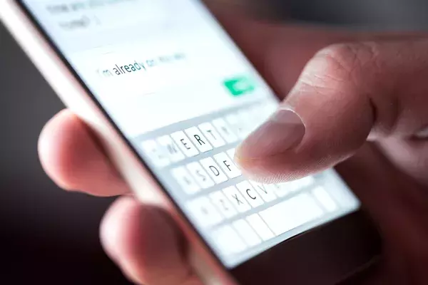 A thumb typing out an SMS on a smartphone