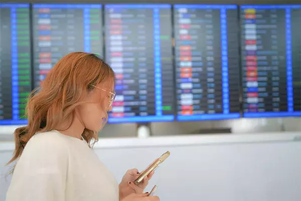 Woman looking at phone in an airport